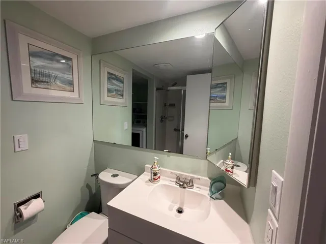 Bathroom vanity featuring a white countertop with an integrated sink, chrome-finish faucet, and a large wall-mounted mirror