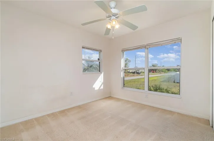 Unfurnished room featuring light carpet and ceiling fan