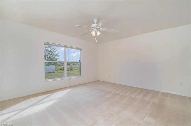 Carpeted empty room featuring ceiling fan