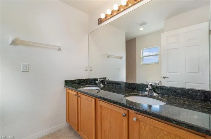 Bathroom featuring tile patterned floors, vanity, and toilet
