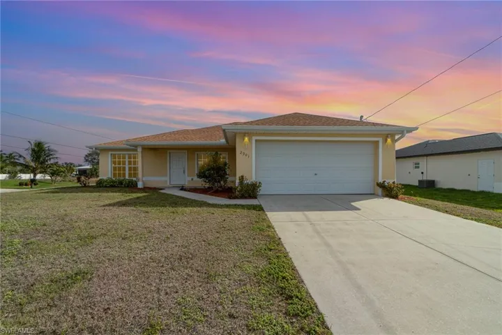 Ranch-style home featuring a lawn, central AC, and a garage
