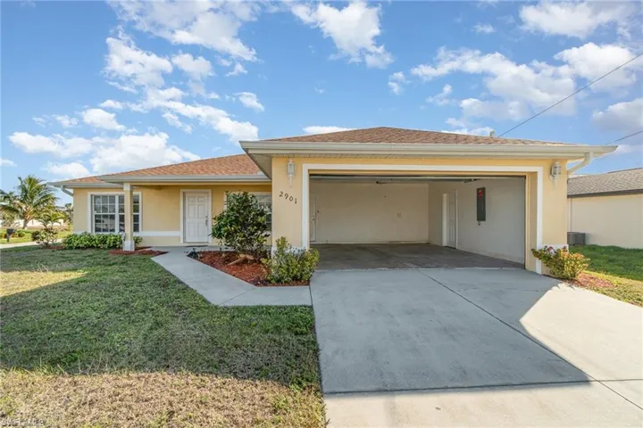View of front of house with a garage and a front yard
