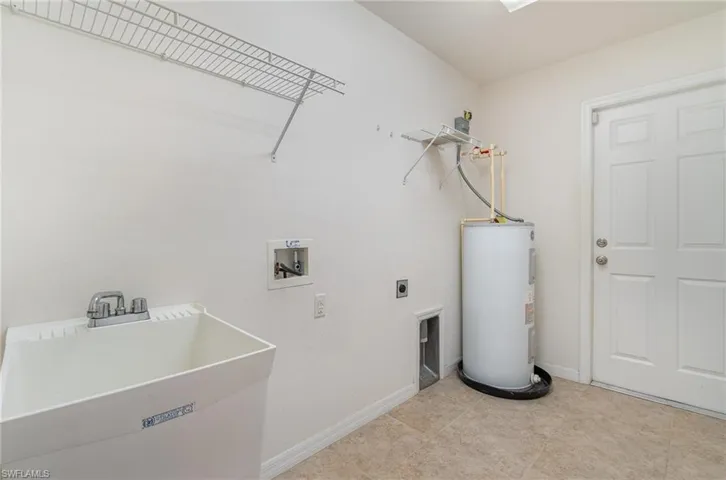 Laundry room featuring hookup for an electric dryer, hookup for a washing machine, electric water heater, and sink