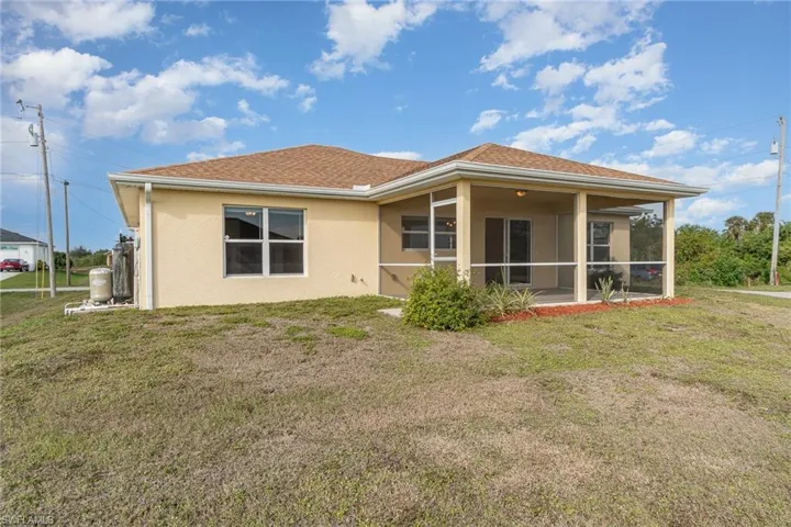 Back of house with a sunroom and a yard