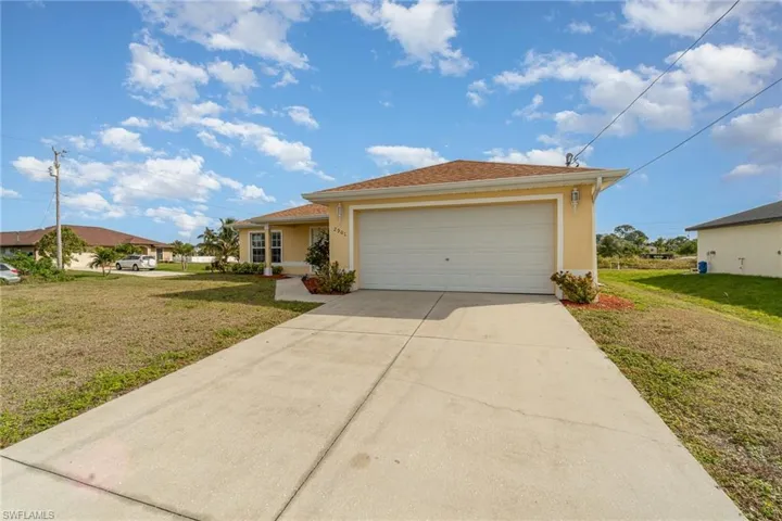 View of front of house with a front lawn and a garage