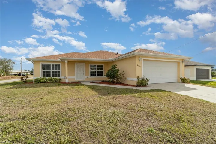Single story home with a garage and a front yard