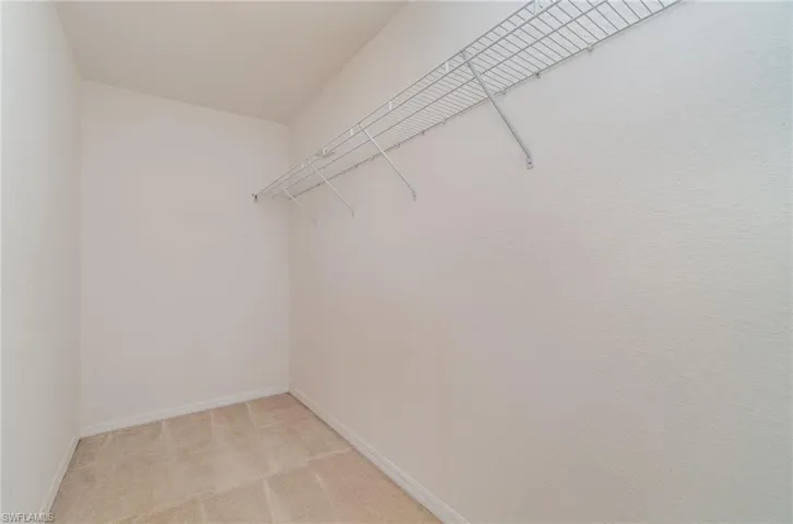 Walk in closet featuring light colored carpet