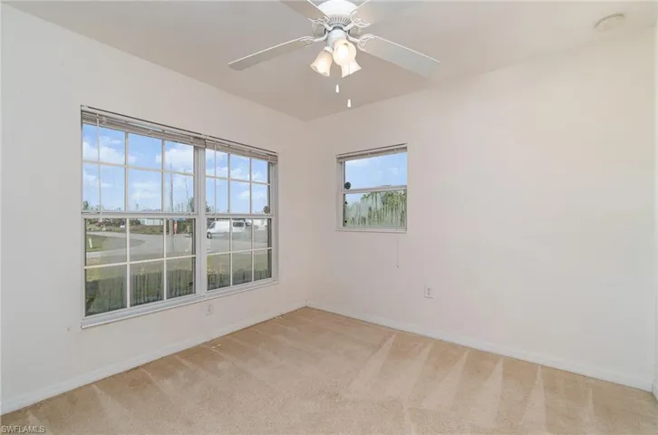 Carpeted spare room featuring ceiling fan