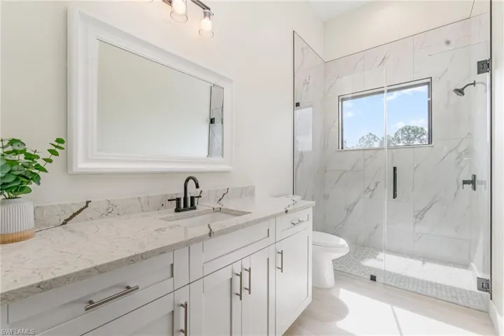 Full bathroom featuring vanity and a marble finish shower