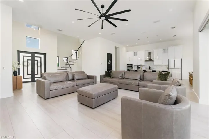 Living room with recessed lighting, stairs, and light wood-style floors
