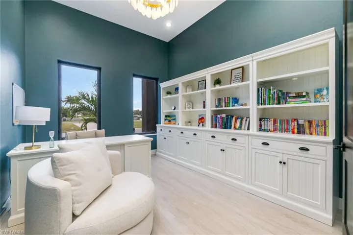 Den or office with light wood-tile flooring and a chandelier