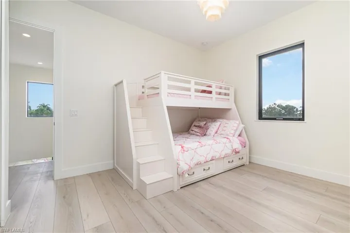 Bedroom with light wood-style floors and multiple windows
