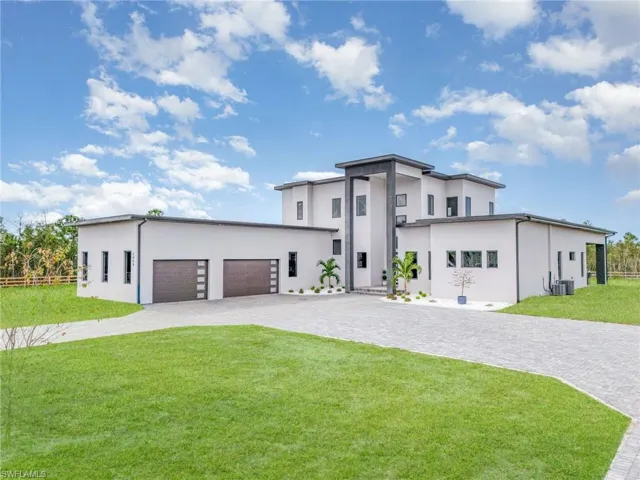 Contemporary house with stucco siding, decorative driveway, and an attached garage