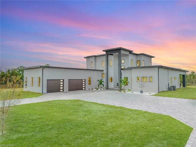 Contemporary home with decorative driveway, stucco siding, and an attached garage