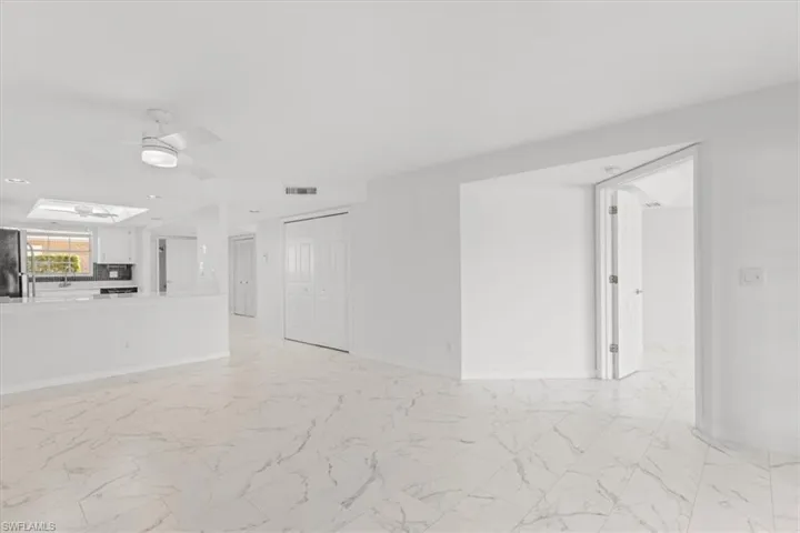 Unfurnished living room with a skylight, sink, light tile patterned floors, and ceiling fan