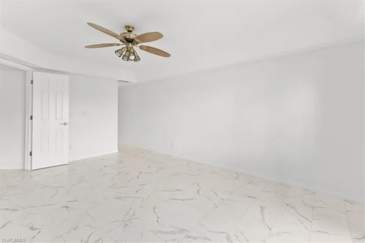 Spare room with ceiling fan and light tile patterned floors