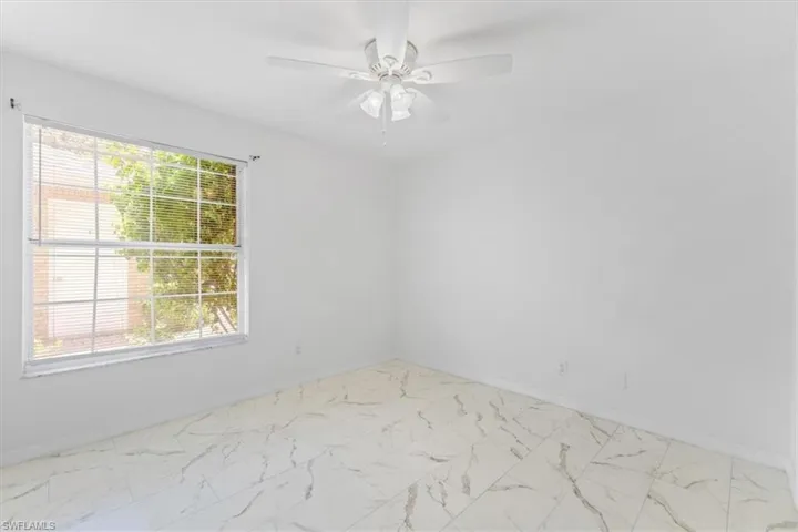 Unfurnished room with light tile patterned flooring and ceiling fan