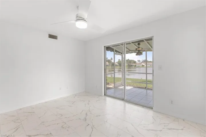 Spare room featuring light tile patterned floors, ceiling fan, and a water view