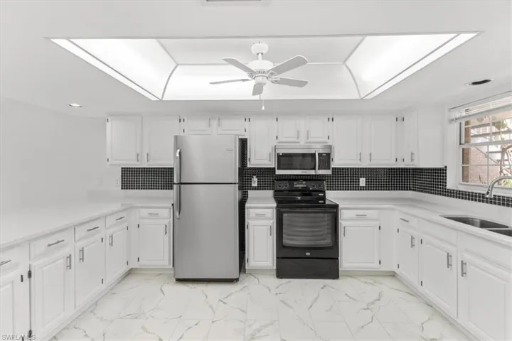 Kitchen featuring light tile patterned floors, stainless steel appliances, tasteful backsplash, and sink