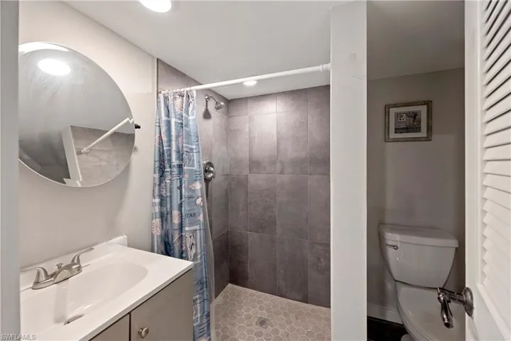 Bathroom featuring vanity, toilet, and walk in shower