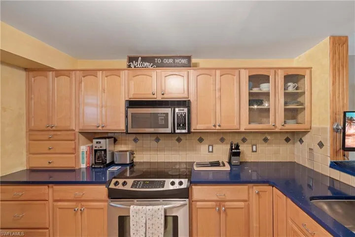 Kitchen with light brown cabinetry and stainless steel appliances