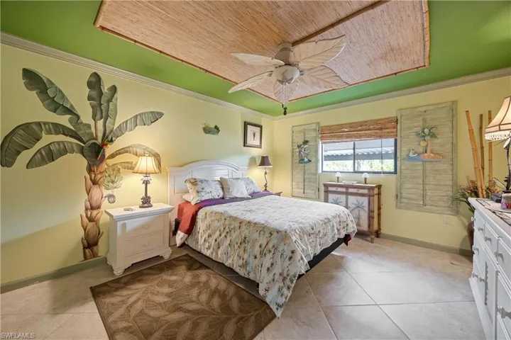 Bedroom featuring ceiling fan, crown molding, light tile patterned flooring, and wood ceiling