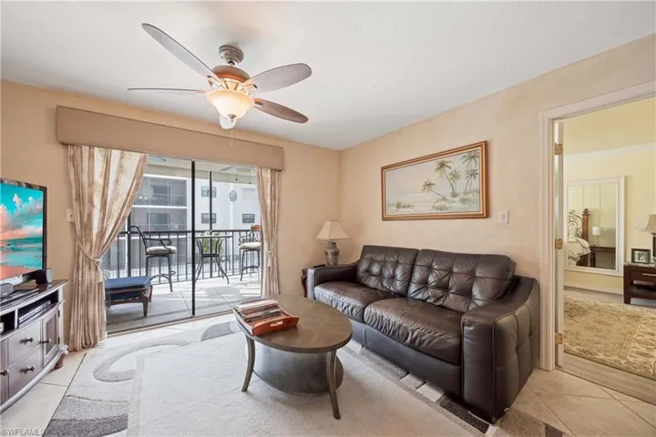 Living room featuring ceiling fan and light tile patterned floors