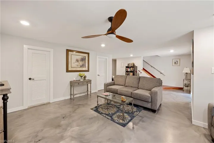 Living room featuring ceiling fan and concrete flooring