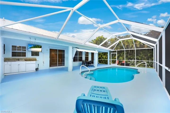 Outdoor pool with a lanai, a sunroom, a patio, and outdoor dining area