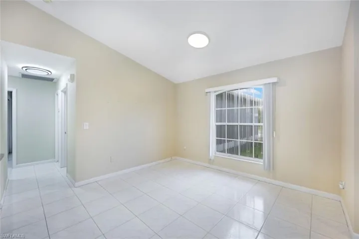 Unfurnished room with lofted ceiling and baseboards
