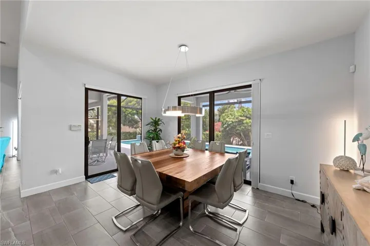 Spacious interior with large format tile flooring and a contemporary linear pendant light fixture
