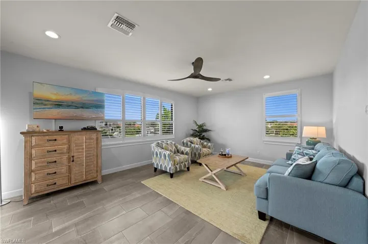 Spacious living area featuring wood-finish tile flooring and recessed lighting
