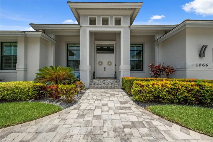 Contemporary stucco exterior with a prominent portico entry and double doors