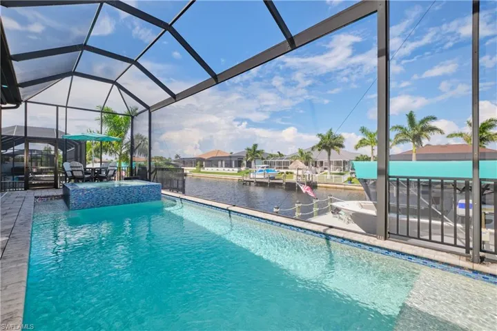View of swimming pool with an in ground hot tub, a patio, and a lanai