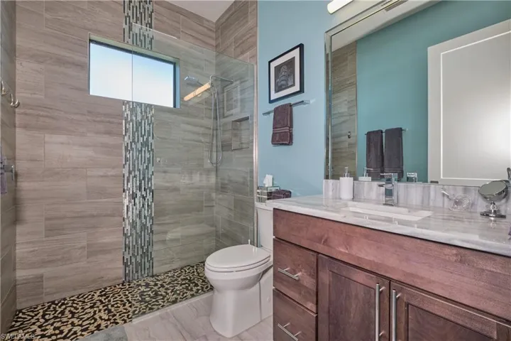 Bathroom with tile patterned floors, toilet, a shower with door, and vanity