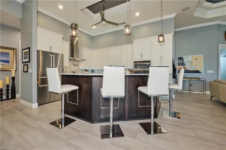 Kitchen with ceiling fan, a center island, stainless steel appliances, and white cabinets