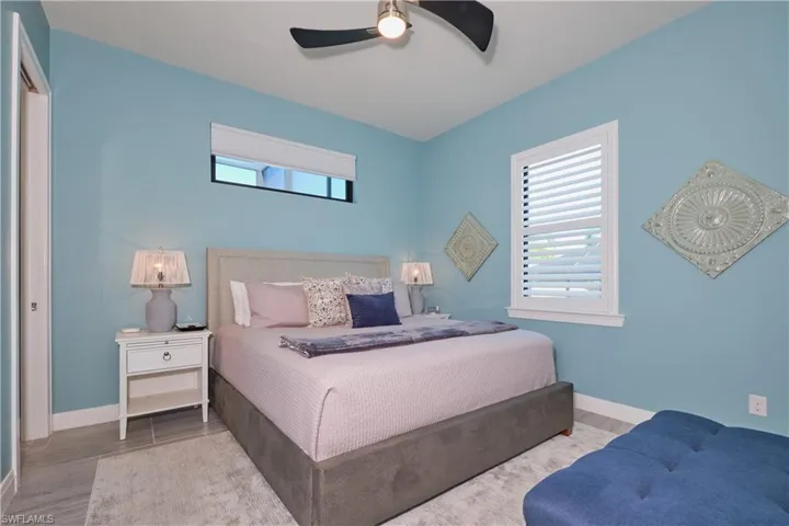 Bedroom featuring ceiling fan, light hardwood / wood-style flooring, and multiple windows
