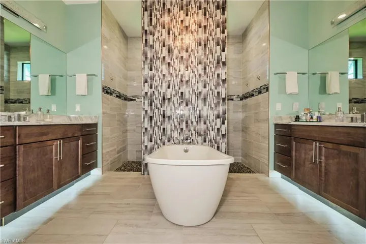 Bathroom featuring tile walls, tile patterned flooring, and vanity