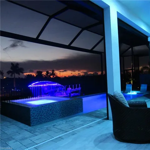 Patio terrace at dusk featuring a swimming pool with hot tub