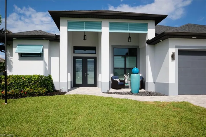Property entrance featuring french doors, a garage, and a yard