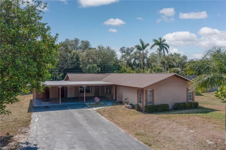 Single-story residence featuring a covered carport, stucco exterior, and a shingle roof