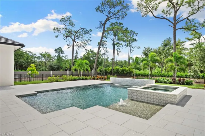 View of pool featuring an in ground hot tub, pool water feature, and a patio area