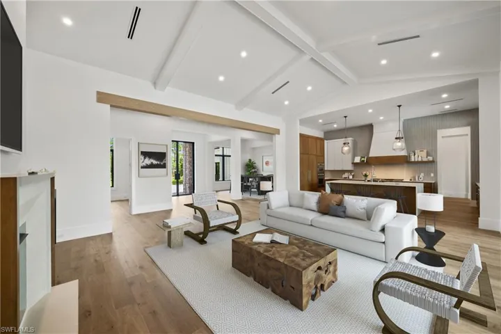Living room featuring lofted ceiling with beams and light hardwood / wood-style flooring