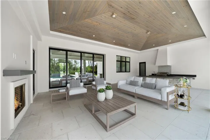 Living room with a towering ceiling, a raised ceiling, and wooden ceiling
