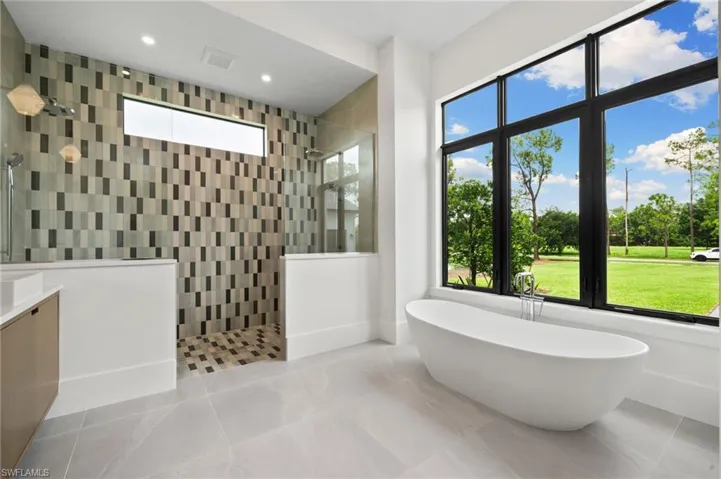 Bathroom featuring plus walk in shower, plenty of natural light, and vanity