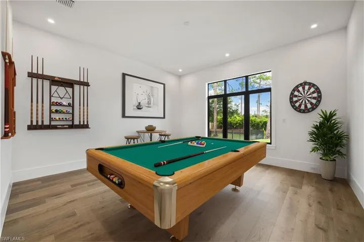 Game room with wood-type flooring and pool table