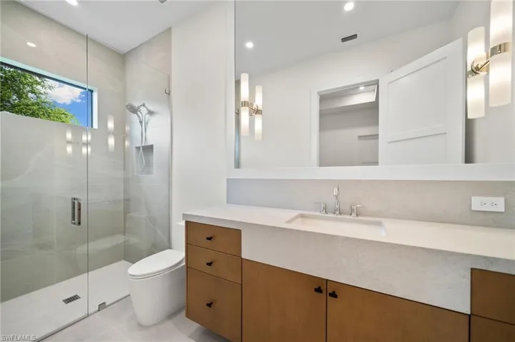Bathroom with vanity, toilet, tile patterned floors, and a shower with shower door