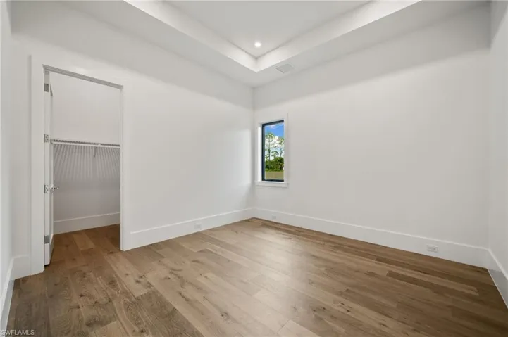 Unfurnished bedroom featuring light hardwood / wood-style flooring, a closet, and a spacious closet