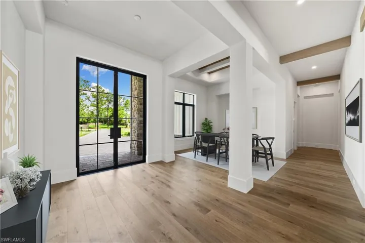 Foyer with hardwood / wood-style floors, french doors, and beam ceiling