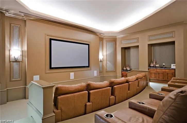 Carpeted cinema room with crown molding
